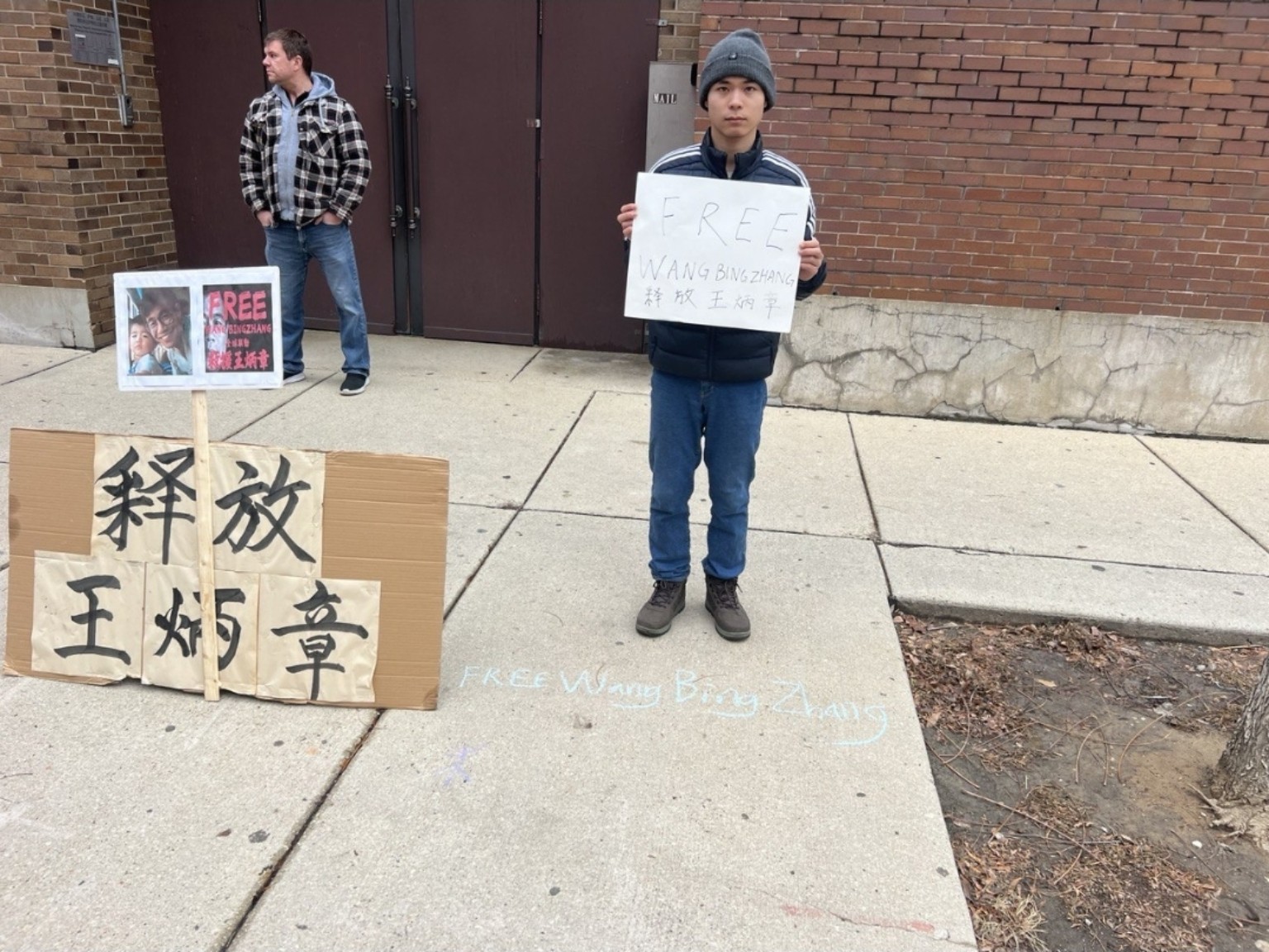 青年参与者手持释放王炳章标语