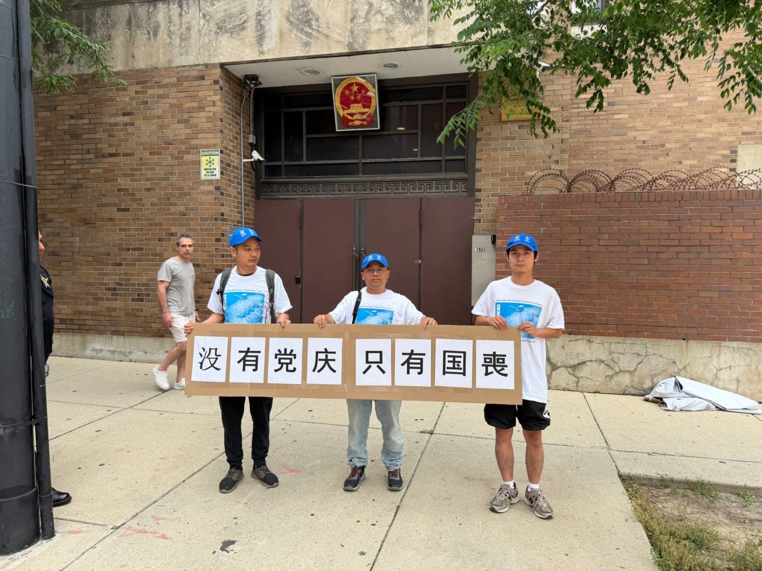 三位参与者举起“没有党庆，只有国殇”标语