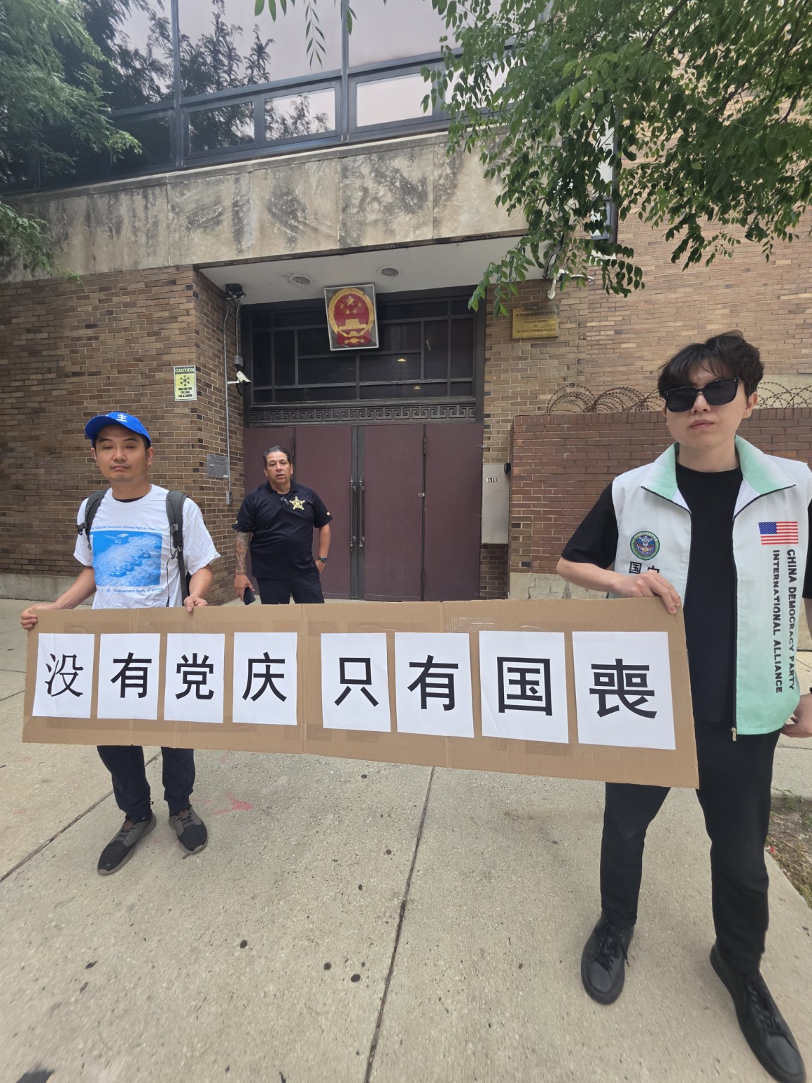 两位参与者再次展示“没有党庆，只有国殇”标语